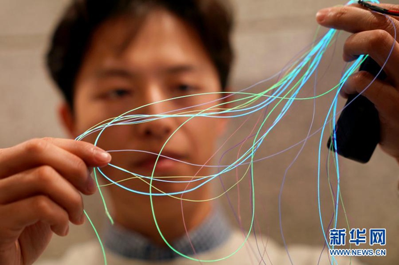 3월 10일, 푸단대 연구진이 편직에 사용되는 발광성 섬유를 보여주고 있다. [사진 출처: 신화망]