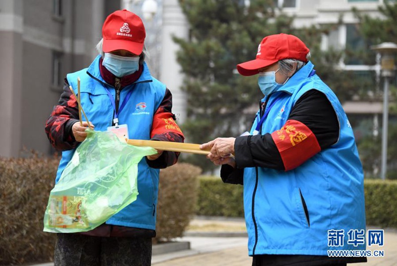 타이위전 할머니(왼쪽)와 자원봉사자 우징이 씨가 단지 순찰 중 쓰레기를 치우고 있다. [3월 5일 촬영/사진 출처: 신화망]