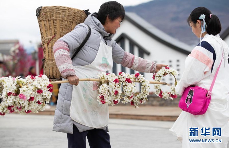 현지 주민이 배꽃, 복숭아꽃을 화환으로 만들어 관광객에게 팔고 있다. [3월 6일 촬영/사진 출처: 신화망]