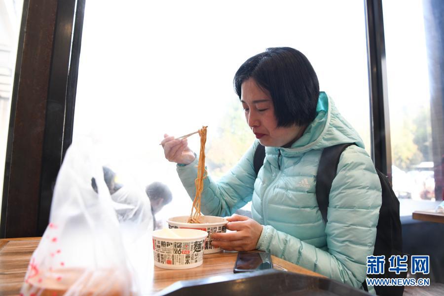 3월 14일, 저우궈훙이 우한의 한 조식 식당에서 우한의 대표 음식 러간몐을 먹고 있다. [사진 출처: 신화망]