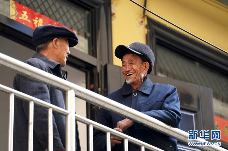 2021년 3월 9일, 류칭지 할아버지(오른쪽)가 마을 주민과 이야기를 나누고 있다. [사진 출처: 신화망]
