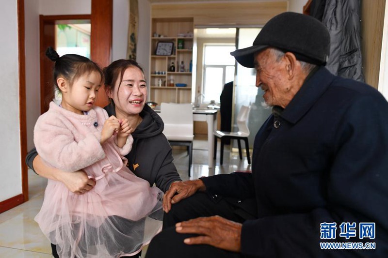 2021년 3월 10일, 류칭지 할아버지의 손녀 류샤오메이(劉小梅, 왼쪽 두번째)가 할아버지와 이야기를 나누고 있다. [사진 출처: 신화망]