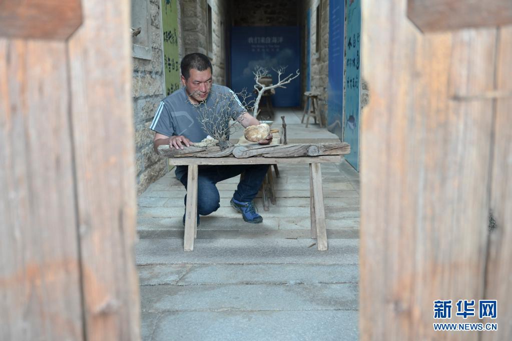 차이징샹 씨는 해변 예술품 전시관으로 개조한 고향 집에서 배 조각, 조개껍질 및 산호를 가지고 작품을 만든다. [4월 19일 촬영/사진 출처: 신화망]