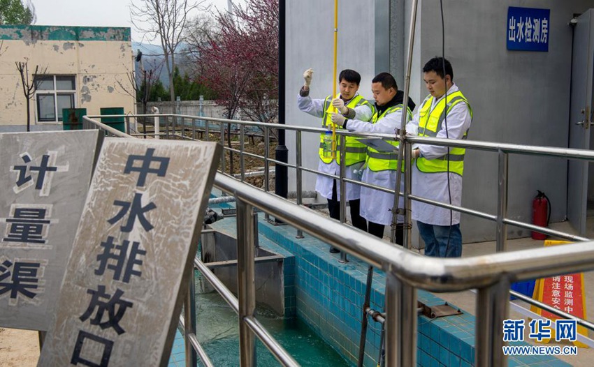 뤄난현 환경관측센터 직원들이 뤄난현 오수처리장 배출구에서 정기 샘플 채취작업을 진행한다. [2020년 4월 11일 촬영/사진 출처: 신화망]