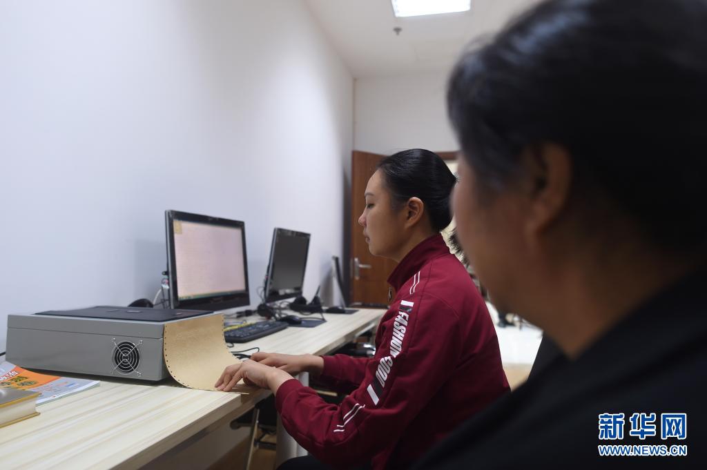 예징펑 씨가 어머니 린펑위 씨와 함께 롱취안시 도서관 시각장애인 전자 열람실에서 점자 자료를 살펴보고 있다. [4월 28일 촬영/사진 출처: 신화망]