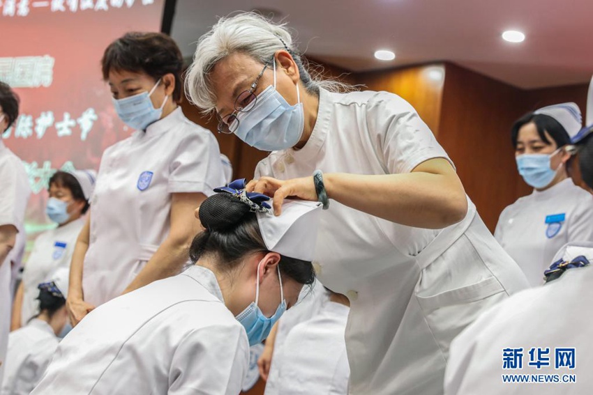 선배 간호사인 옌펑링(閆鳳玲·가운데)이 신입 간호사에게 모자를 수여하고 있다. [5월 10일 촬영/사진 출처: 신화망]