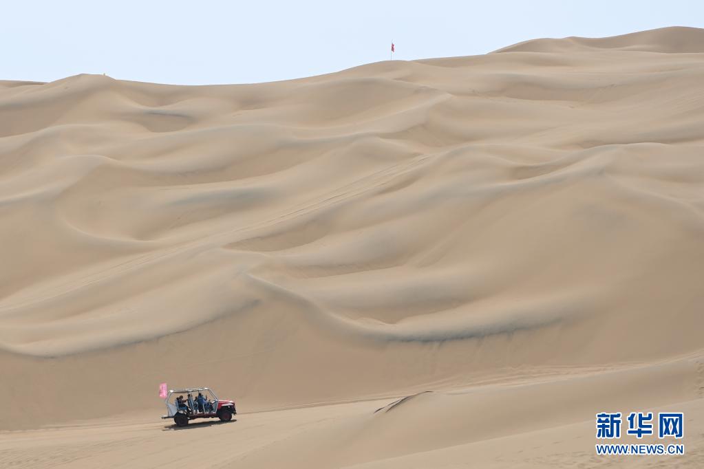 관광객이 신장 산산현 쿠무타거사막 관광지에서 서핑카를 타고 사막을 관광하고 있다. [5월 16일 촬영/사진 출처: 신화망]