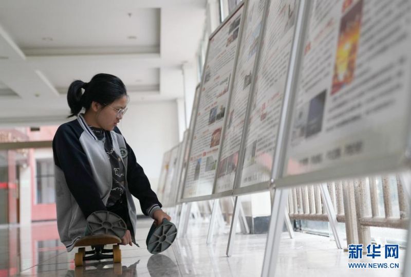 장장쯔이가 학교 복도에서 포스터를 본다. [사진 출처: 신화망]