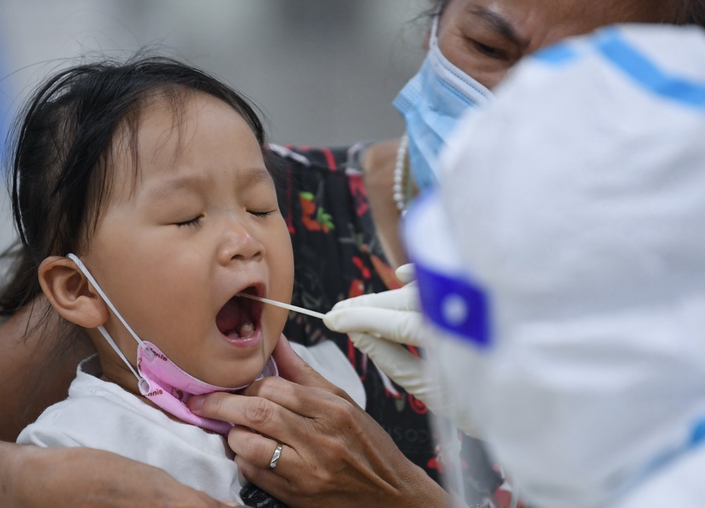 광저우 리완구 체육관 핵산검사소, 의료진이 한 어린이에게 핵산 샘플 채취 중이다. [5월 26일 촬영/사진 출처: 신화망]