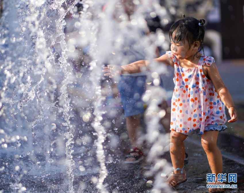 어린이가 상업거리의 분수에서 물놀이를 하고 있다. [사진 출처: 신화망]