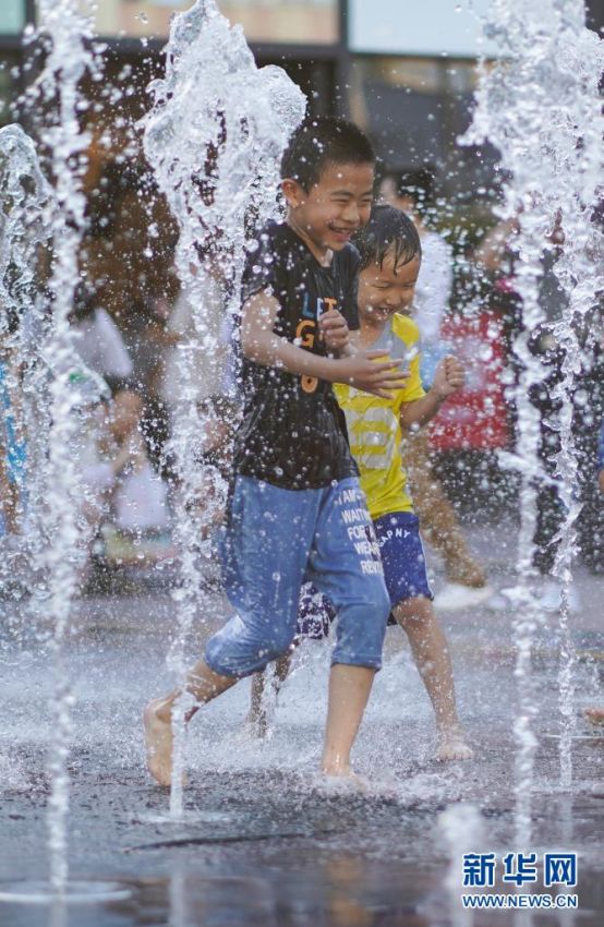 어린이들이 상업거리의 분수에서 물놀이를 하고 있다. [사진 출처: 신화망]