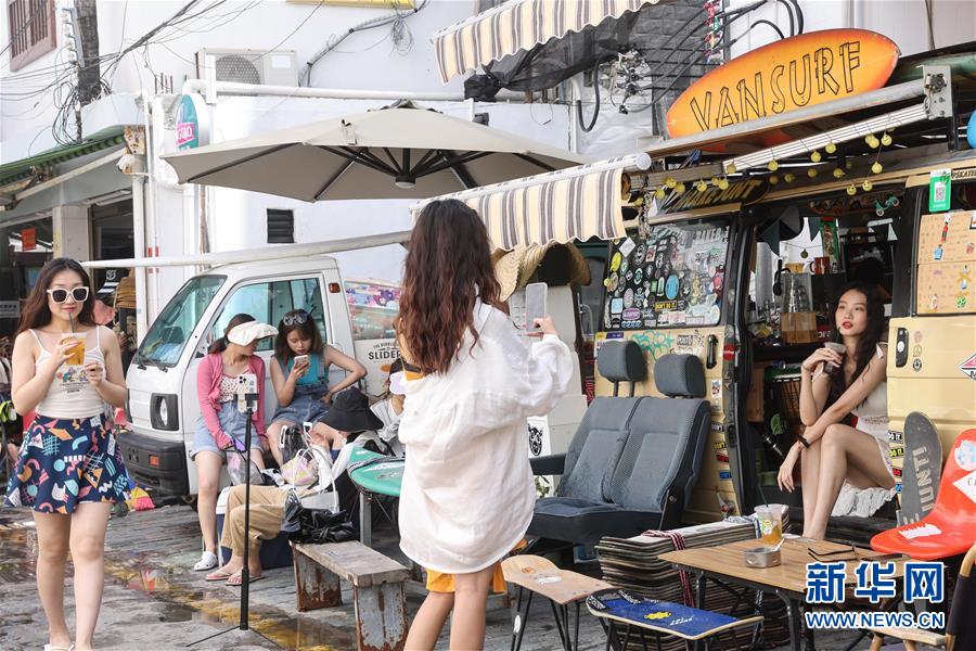 관광객이 텅하이 어촌의 특색 음식점 앞에서 기념사진을 촬영한다. [7월 8일 촬영/사진 출처: 신화망]