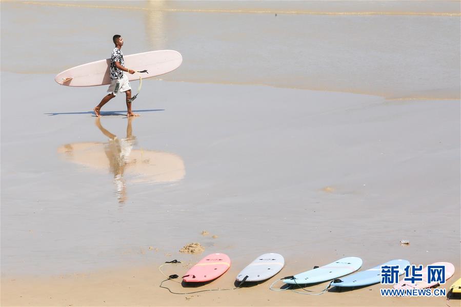 한 서퍼가 텅하이 어촌의 모래사장을 걷고 있다. [7월 8일 촬영/사진 출처: 신화망]