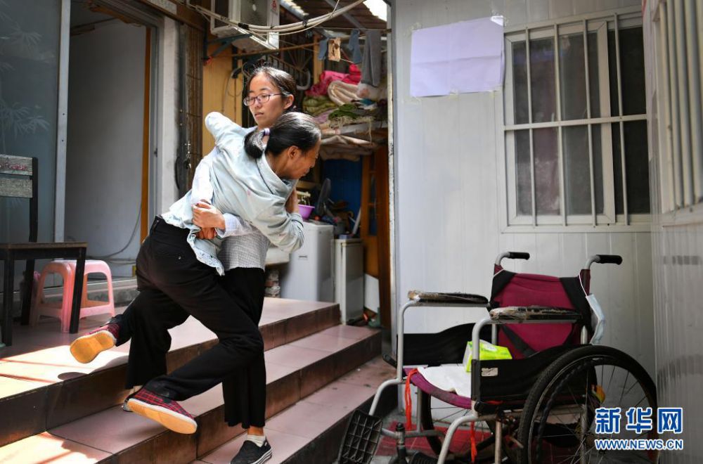 양주메이 씨가 어머니를 안고 월세방 계단을 내려가고 있다. [6월 8일 촬영/사진 출처: 신화망]