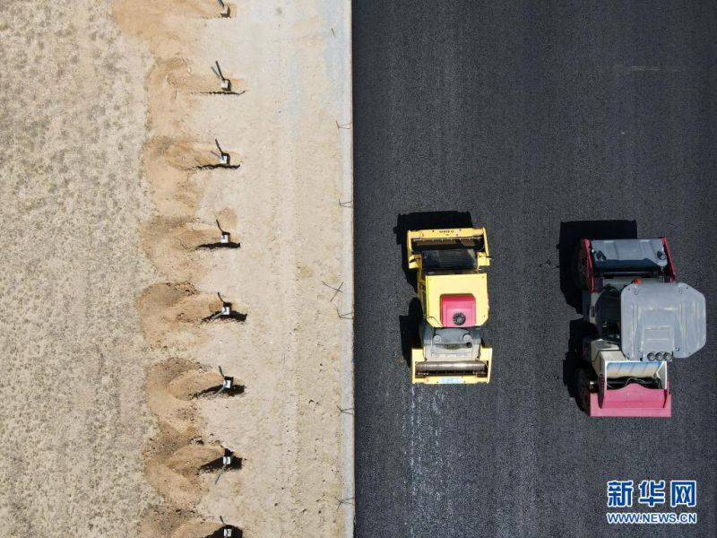 인부가 기계로 아우 고속도로 2기 공사 현장에서 아스팔트를 깔고 있다. [7월 16일 드론 촬영/사진 출처: 신화망]