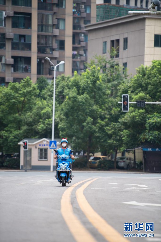 8월 9일, 장자제 융딩구 융딩거리에서 옌잉자오 씨가 오토바이를 타고 배달을 하고 있다. [사진 출처: 신화망]