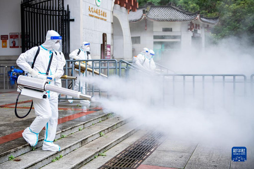 8월 26일, 장자제 톈먼산 관광지 입구에서 직원들이 줄 서는 통로를 소독하고 있다. [시진 출처: 신화사]