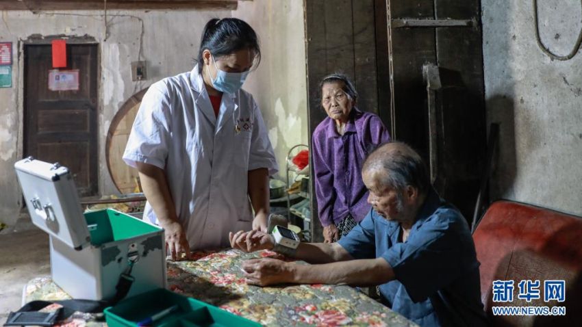 8월 17일, 주위촌 뉴광둔에서 양샤오옌 씨(오른쪽)가 촌민 탄차이쥔(譚彩均)의 신체 검사를 하고 있다. [사진 출처: 신화망]