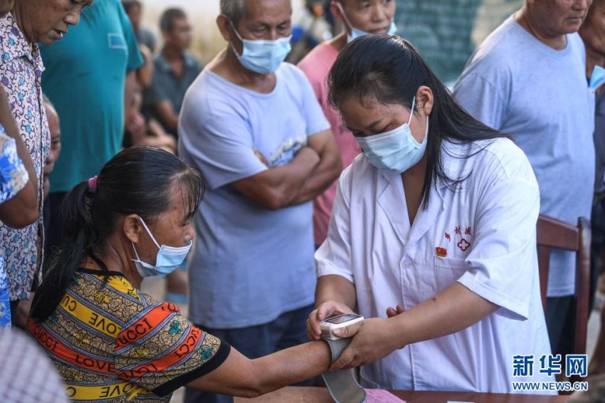 8월 18일, 양샤오옌 씨가 촌민에게 접종하기 위해 혈압을 측정하고 있다. [사진 출처: 신화망]