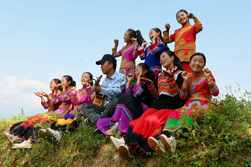 쓰촨성 량산이족자치주 푸거현 다차오향에서 뉴뉴 합창단원과 지부샤오룽 선생이 야외에서 노래를 부르고 있다. [사진 출처: 신화사]