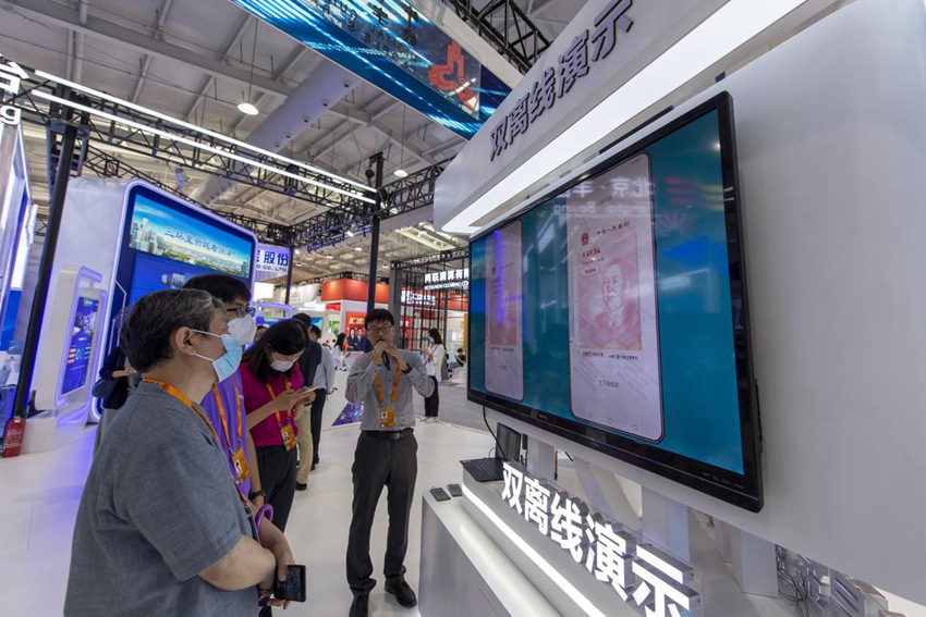 9월 4일, 중국서비스무역교역회 디지털위안화 전시구역에 많은 관심이 쏠렸고, 관람객들은 양방향 오프라인결제 기술을 파악하는 중이다. [사진 출처: 인민망]