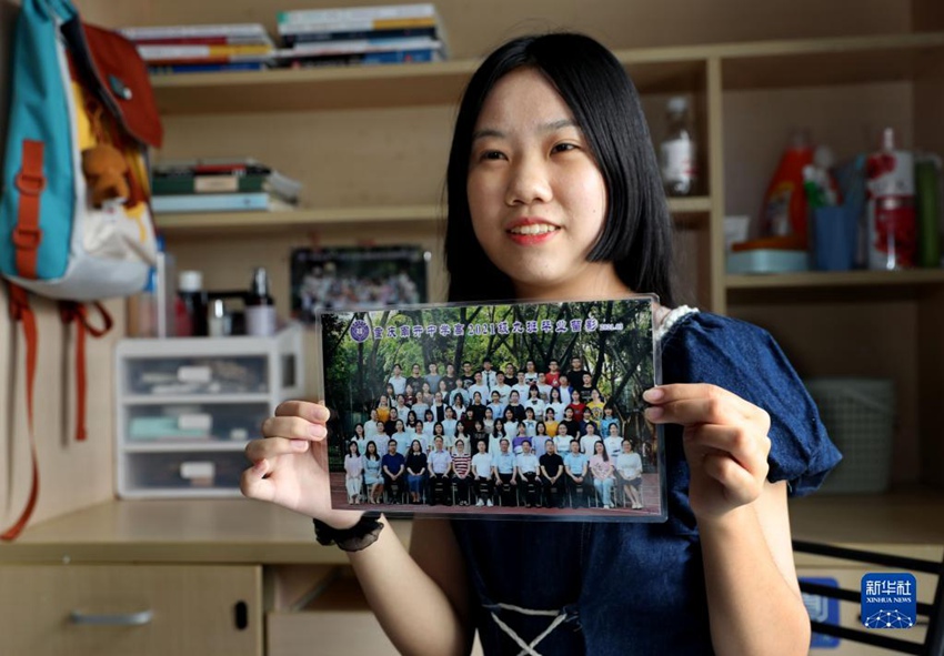 충칭(重慶)에서 온 덩신이(鄧欣怡)가 자신의 고등학교 졸업사진을 보여주고 있다. [사진 출처: 신화사]