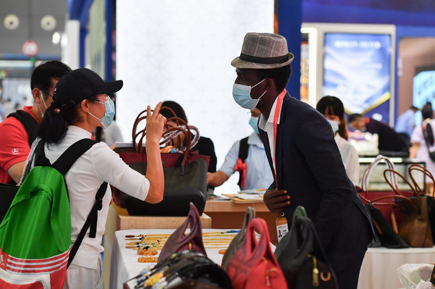 관람객들이 아프리카 상품 전시구역에서 참가 기업에게 아프리카 상품 설명을 듣고 있다. [사진 출처: 신화사]