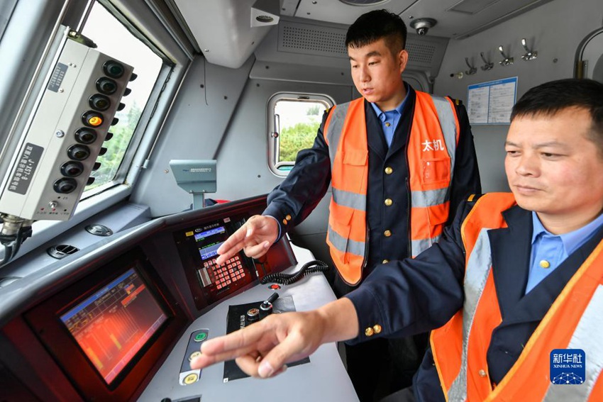 9월 28일 리궈칭(왼쪽) 씨가 동료와 함께 열차를 운행 중이다. [사진 출처: 신화사]