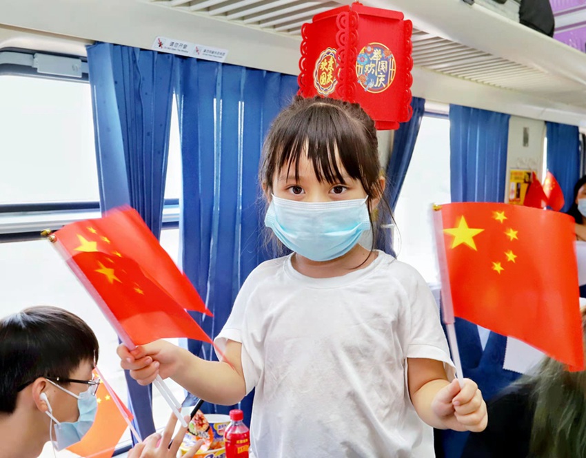 여자 아이가 오성 홍기를 기쁘게 흔들고 있다. [사진 출처: 인민망]