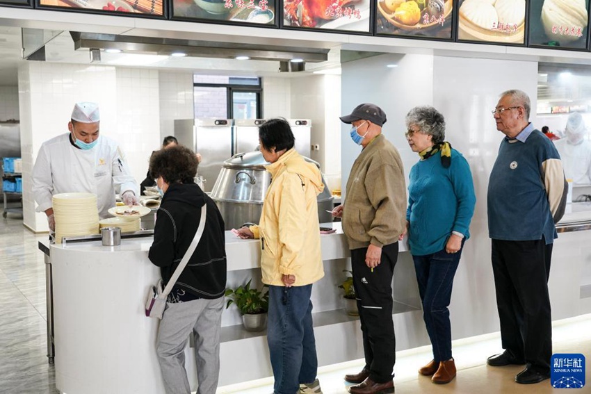 뤼웨이예(오른쪽 1번째)와 리잔핑(왼쪽)이 실버타운 식당에서 다른 노인들과 함께 줄을 서서 음식을 받고 있다. [10월 12일 촬영/사진 출처: 신화사]