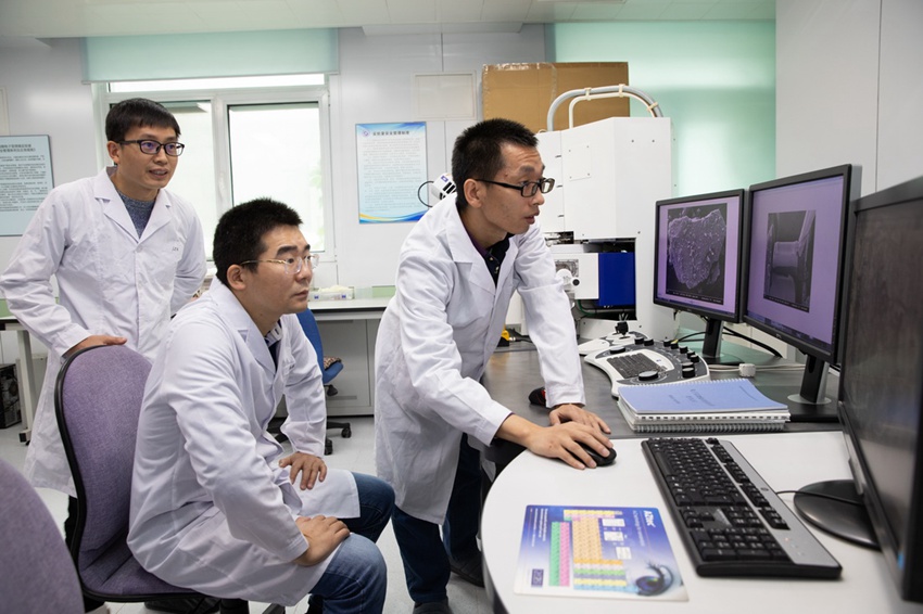 중국과학원 지질 및 지구 물리연구소 전자현미경 실험실에서 과학자들이 실험의 진척 상황에 대해 토론하고 있다. [10월 18일 촬영/사진 출처: 신화사]