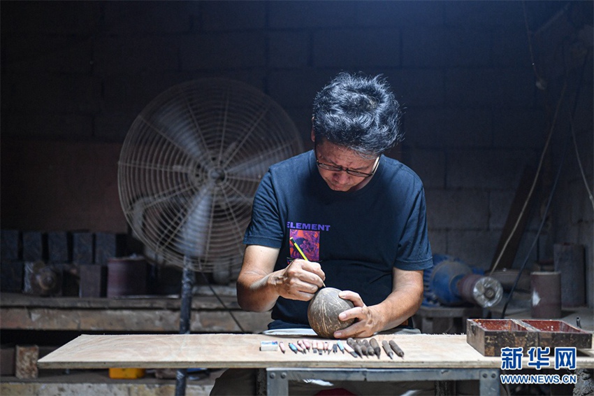 커추펑이 연필로 야자껍질에 조각할 도안을 그린다. [9월 14일 촬영/사진 출처: 신화사]