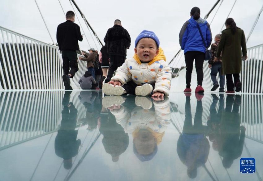 한 아기가 장자제 유리다리에서 부모님이 사진 찍는 것을 기다리고 있다. [11월 12일 촬영/사진 출처: 신화사]