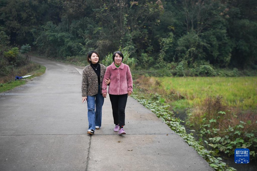 11월 17일, 저우원쥐안(왼쪽)이 장둥어와 후난성 융저우시 허셰(和諧)촌을 걷고 있다. [사진 출처: 신화사]