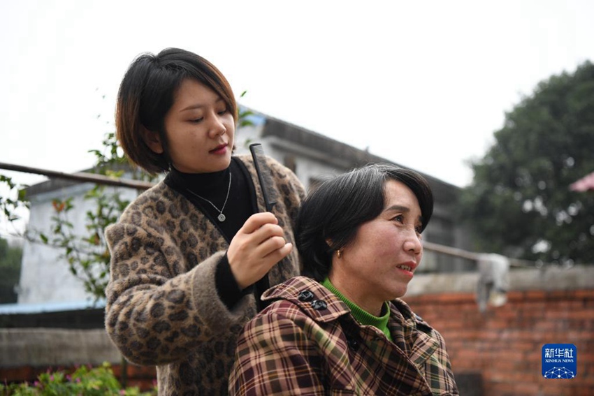 11월 17일, 저우원쥐안(왼쪽)이 마을 주민 장둥어(蔣冬娥)의 머리를 빗겨주고 있다. [사진 출처: 신화사]