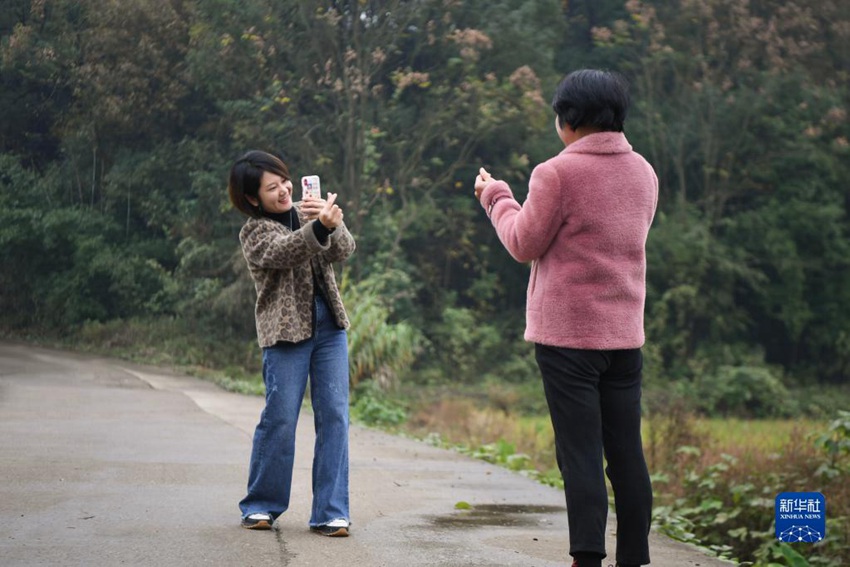 11월 17일, 저우원쥐안(왼쪽)이 장둥어에게 사진을 찍고 있다. [사진 출처: 신화사]