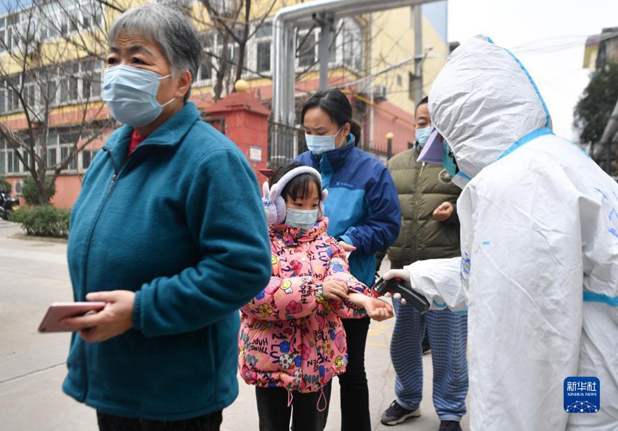 12월 23일, 시안시 롄후(蓮湖)구에서 핵산검사를 받으러 온 시민의 체온를 측정한다. [사진 출처: 신화사]