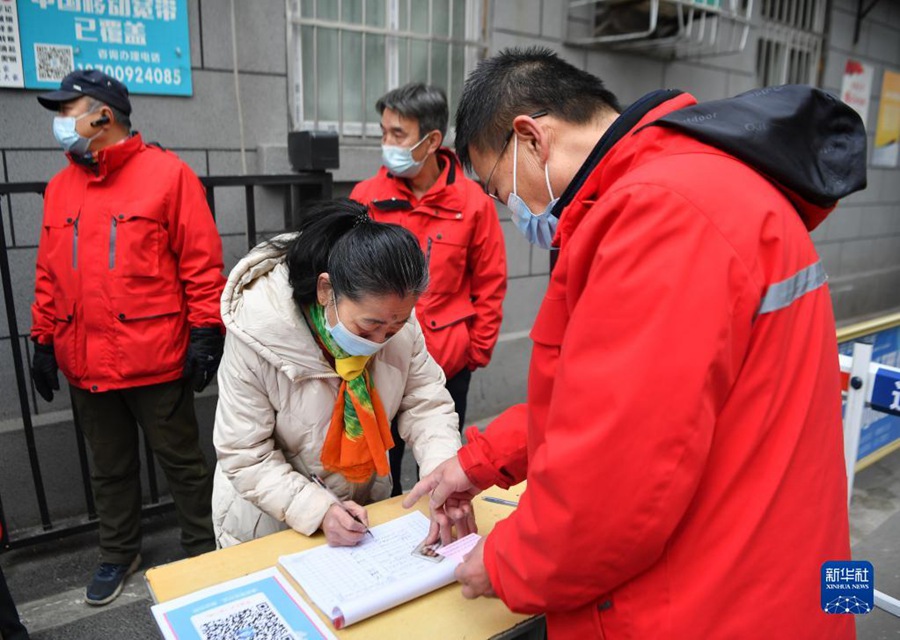 12월 23일, 주택단지를 출입하는 주민들은 정보를 등록한다. [사진 출처: 신화사]