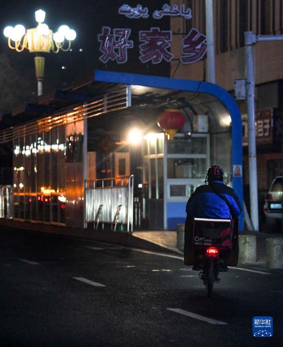 12월 22일 새벽 2시, 우루무치 칭녠(靑年)로, 거리를 다니는 배달원의 모습이 보인다. [사진 출처: 신화사]