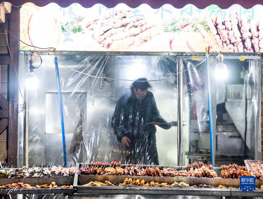 12월 22일 새벽 2시 6분, 우루무치시 훙치(紅旗)로, 한 고기집에서 다 구운 꼬치를 테이블로 보내려 한다. [사진 출처: 신화사]