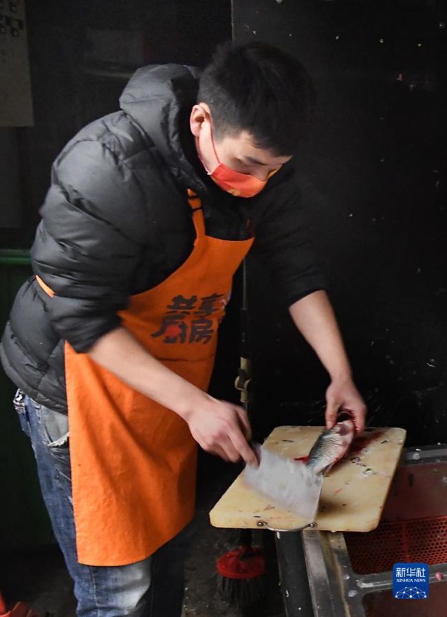 장광빙이 환자 가족을 도와 생선을 손질하고 있다. [12월 14일 촬영/사진 출처: 신화사] 