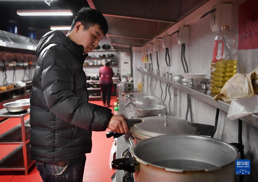 장광빙이 공유 주방에서 무료로 제공하는 팔보죽(八寶粥)을 만들고 있다. [12월 14일 촬영/사진 출처: 신화사]