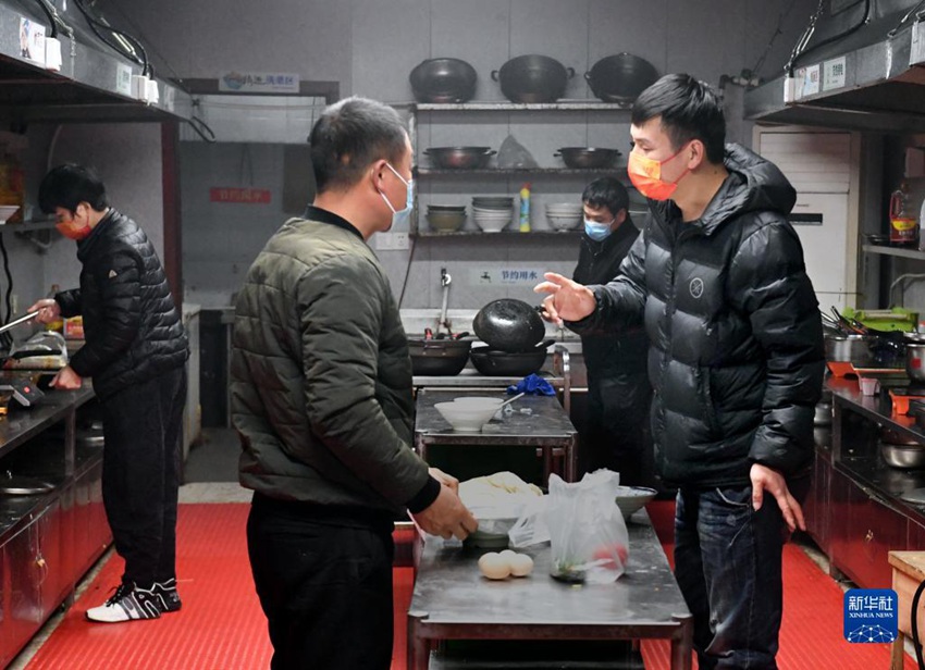 장광빙이 공유 주방에서 요리하는 환자 가족과 이야기를 나누고 있다. [12월 14일 촬영/사진 출처: 신화사]