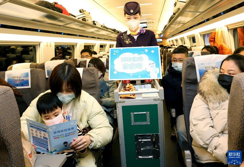 1월 16일, 상하이 훙차오발 한커우행 열차 G1724편에서 승무원들이 승객들에게 방역 홍보책자를 지급한다. [사진 출처: 신화사]