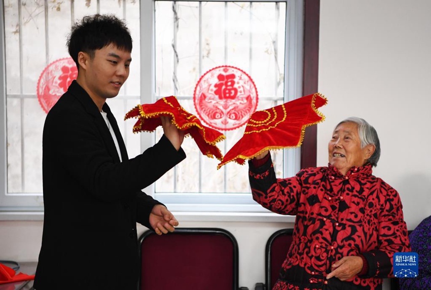 판진린(좌)은 신년회 시작 전에 노인들한테 손수건 돌리기를 배우고 있다. [2021년 12월 31일 촬영/사진 출처: 신화사]