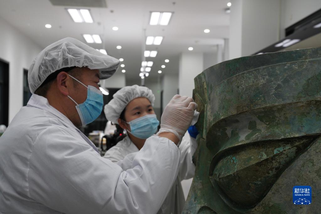 문물보호 직원이 싼싱두이 유적지에서 출토된 대형 청동가면을 복원하고 있다. [사진 출처: 신화사/쓰촨성 문물고고연구원, 싼싱두이박물관 제공] 