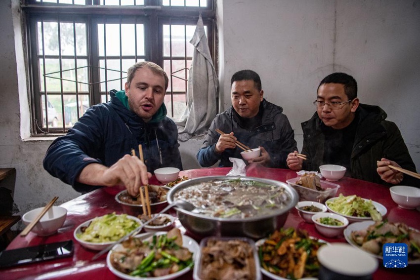 허겅진 바이린(柏林)촌에서 마틴(왼쪽 첫 번째)이 친구들과 현지 명절 음식인 파오주탕(刨豬湯)을 맛보고 있다. [1월 27일 촬영/사진 출처: 신화사]