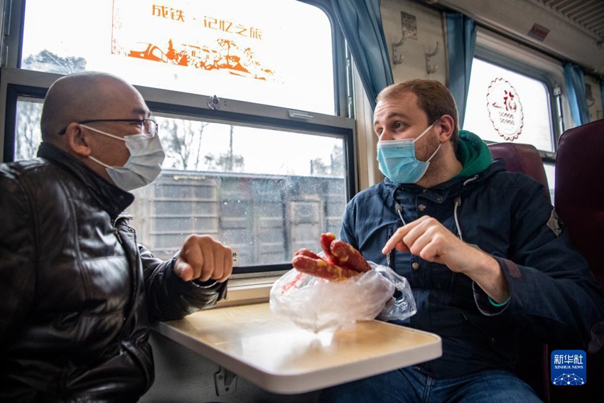 마틴(오른쪽)이 완행열차에서 현지 주민과 중국 소시지와 독일 소시지에 대해 말하고 있다. [1월 27일 촬영/사진 출처: 신화사]