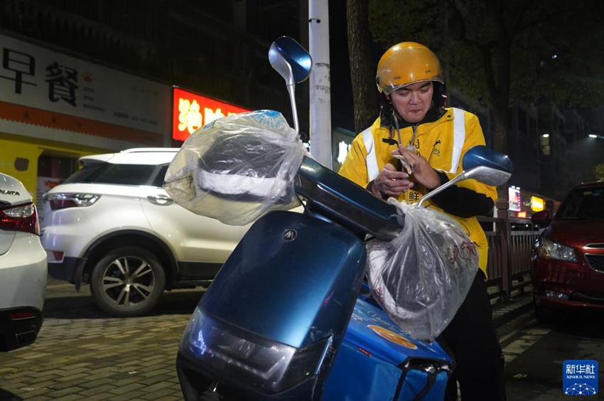 쉬룽칭은 길거리에서 빵을 먹으면서 주문을 기다린다. [1월 19일 촬영/사진 출처: 신화사]