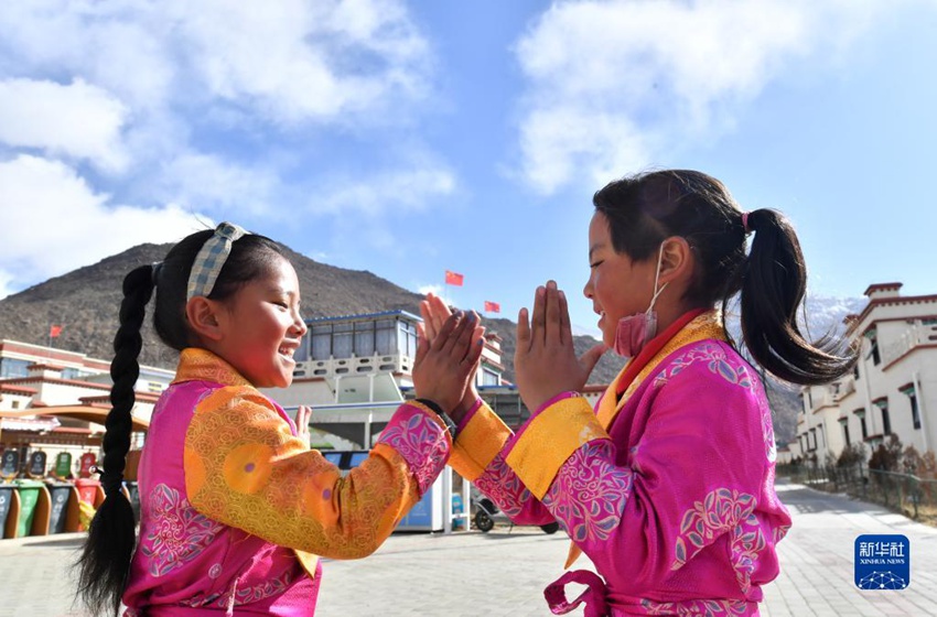이주 목축민 여자아이 두 명이 옷을 제대로 차려입고 이주지에서 전통놀이에 한창이다. [2월 28일 촬영/사진 출처: 신화사] 
